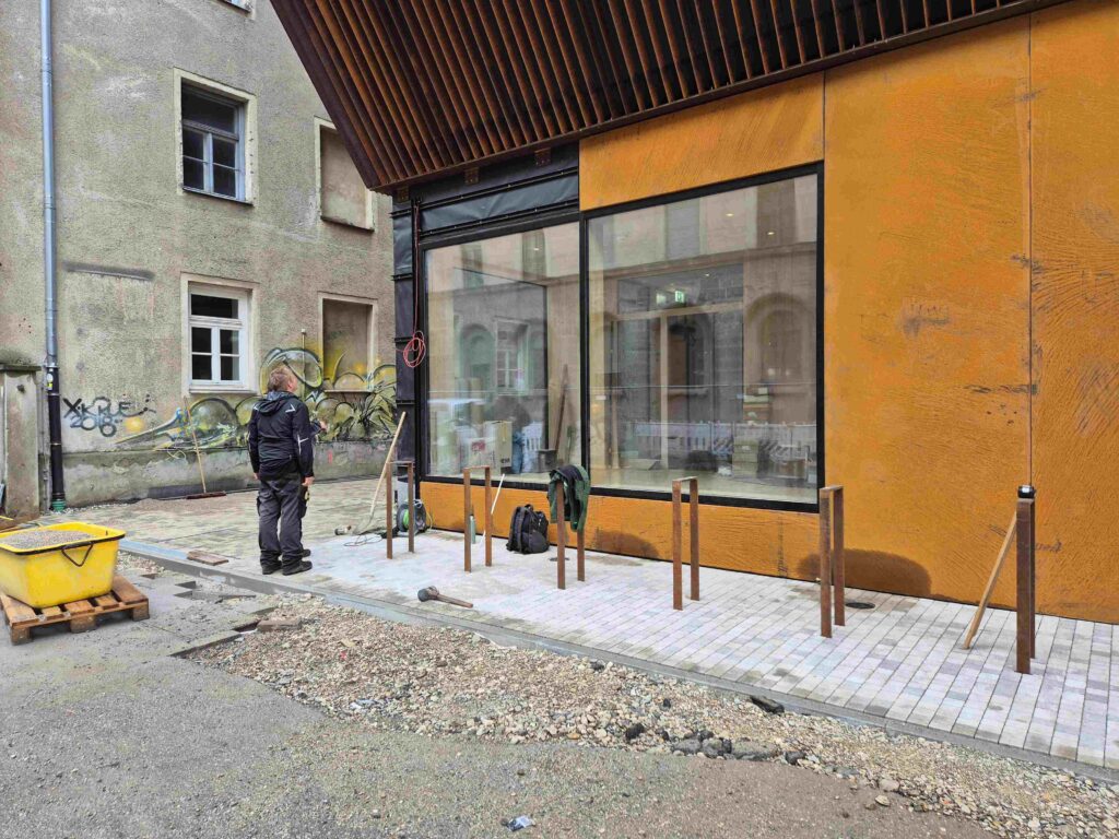 Kinderoase an der TUM: Anbringen der Cortenstahlfassade im Erdgeschoss